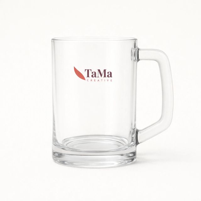 Caneca de chope transparente com alça grande, com a marca TaMa nas cores oficiais no corpo.