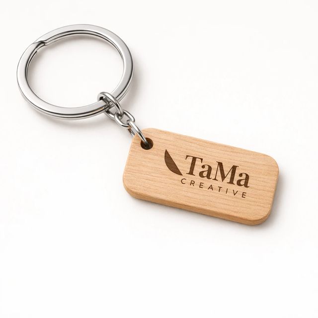 Chaveiro com plaquinha retangular em tom natural e argola prata, com a marca TaMa gravada.