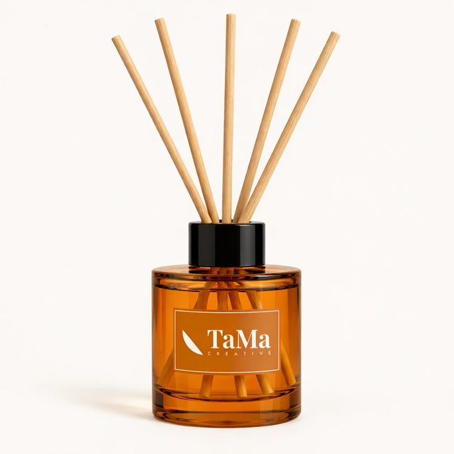 Difusor de aromas em frasco com varetas, na cor âmbar, com a marca TaMa no rótulo.