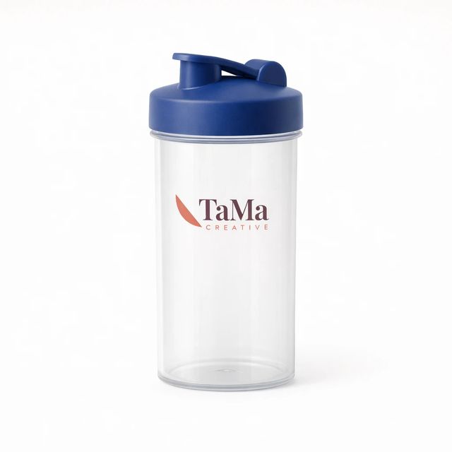 Garrafa shaker transparente com tampa azul royal, com a marca TaMa nas cores oficiais no corpo.