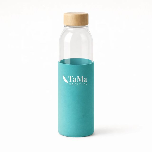 Garrafa transparente com capa turquesa e tampa em tom natural, com a marca TaMa em branco na capa.