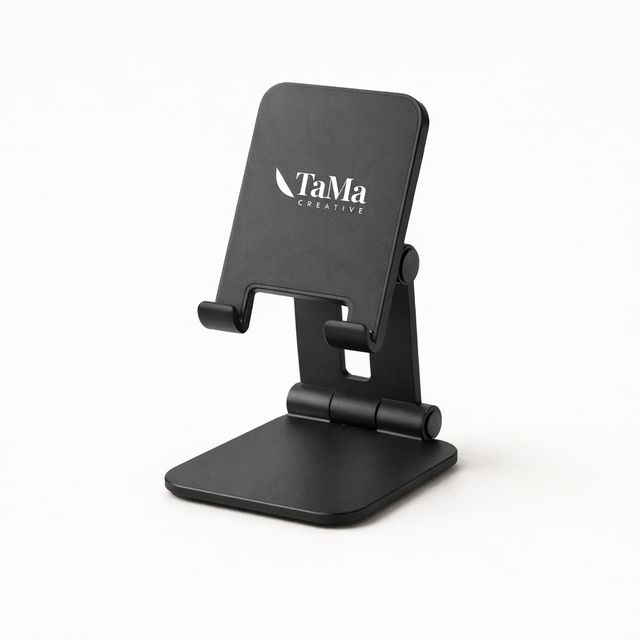 Suporte de celular preto, ajustável, com a marca TaMa em branco no apoio.