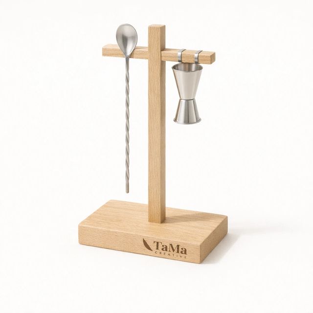 Suporte vertical em tom natural em formato de cruz segurando colher de bar e dosador, com a marca TaMa gravada na base.