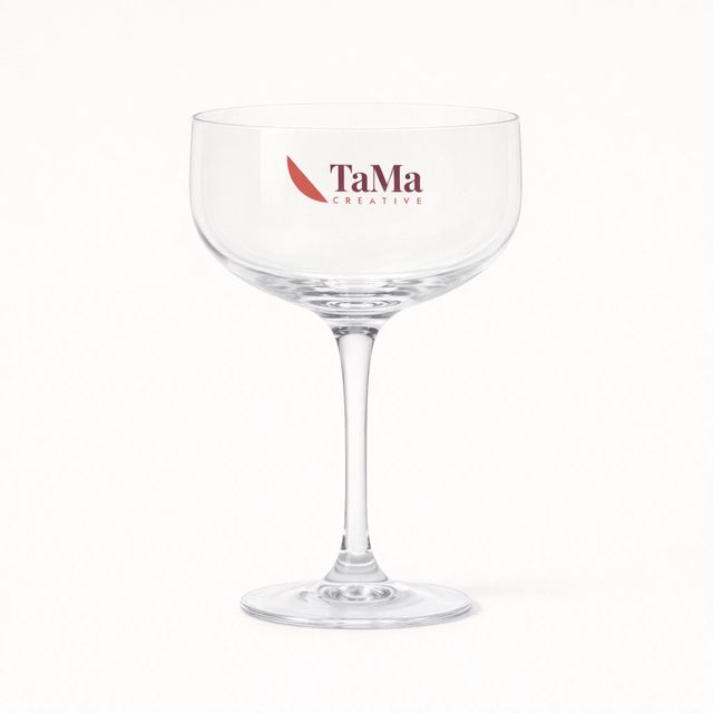 Taça coupe lisa transparente de haste longa, com a marca TaMa nas cores oficiais no bojo.