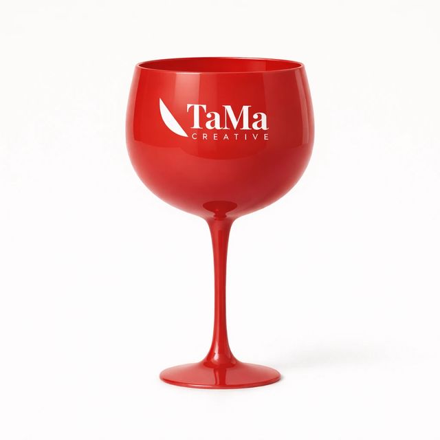 Taça de gin em acrílico vermelho com a marca TaMa em branco no bojo.